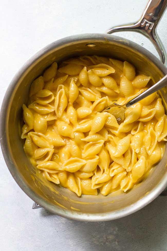 mac and cheese for one in a saucepan with a fork