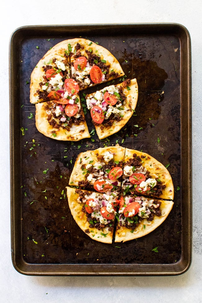 Two Chorizo and Goat Cheese Pita Pizza on a sheet pan