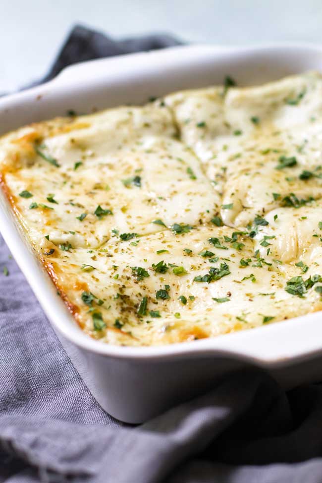 spinach lasagna in a white baking dish