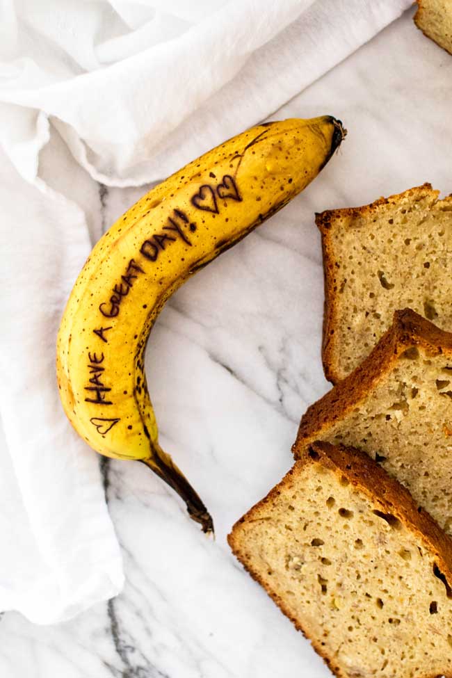 overhead photo of a banana with a message written on it