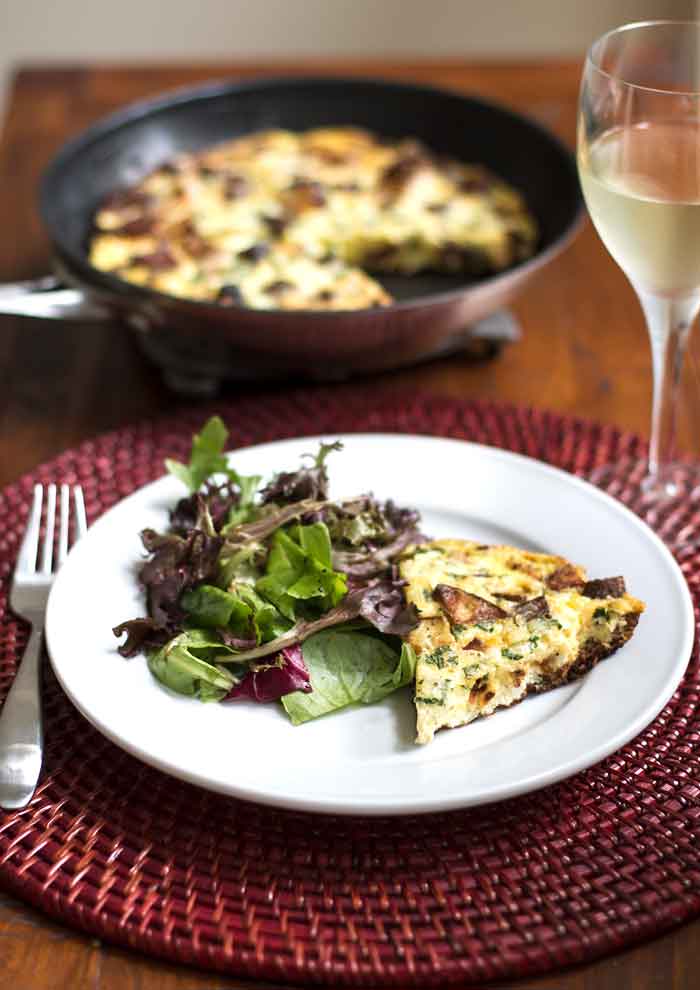 Chorizo Potato Frittata with a glass of wine and a green salad