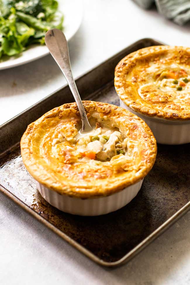 Chicken pot pie with a fork breaking through the flaky crust