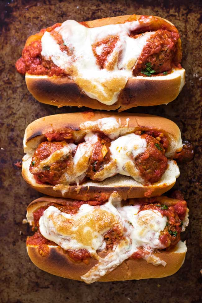 three meatball sandwiches topped with melted mozzarella cheese