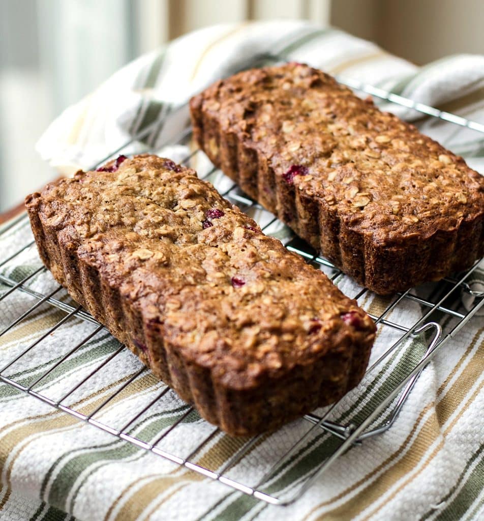 Two loaves of Cranberry Banana Oat Bread on a baking rack