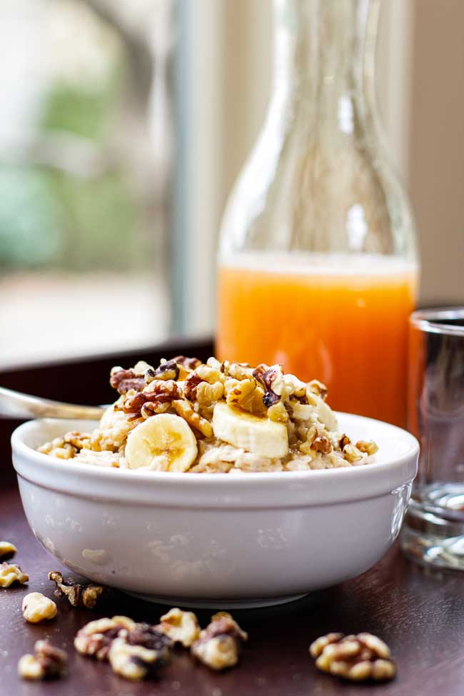 banana nut oatmeal with a jug of grapefruit juice in the background