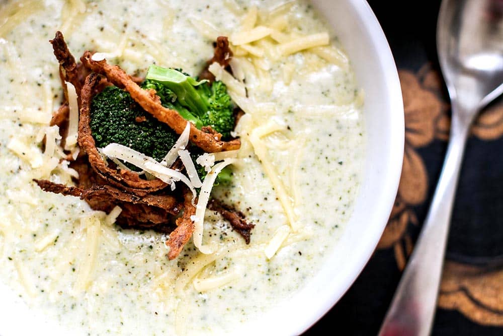 A bowl of broccoli cheese soup garnished with crispy onions