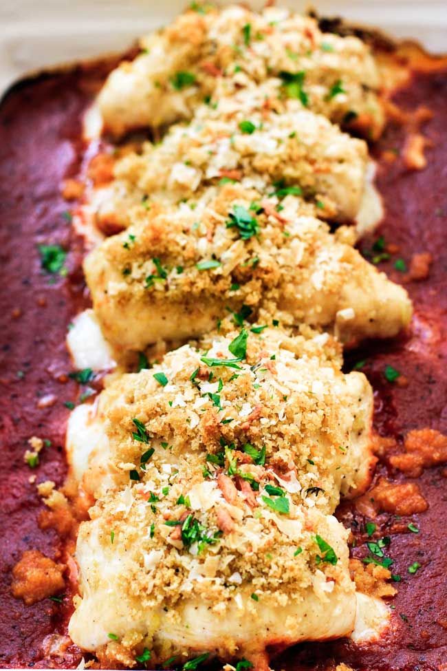 Chicken parmesan roll-ups in a baking dish with tomato sauce