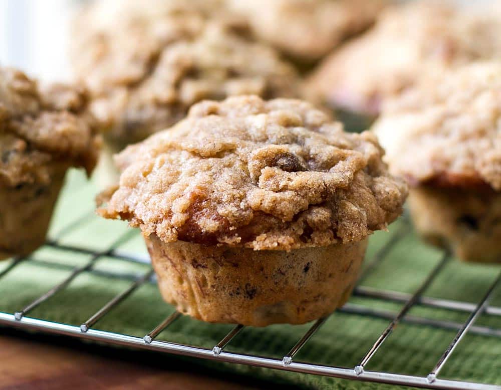 A banana nut muffin on a bakers rack with a green napkin underneath