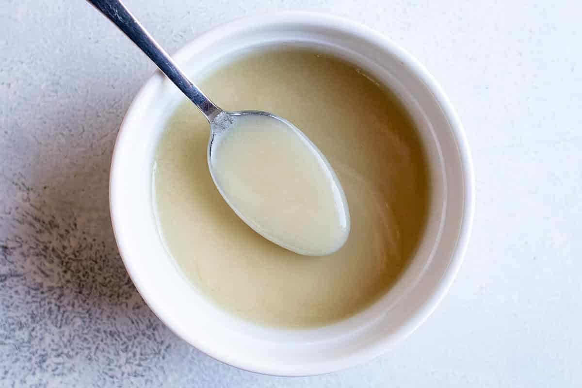 Veloute sauce in a white bowl with a spoon