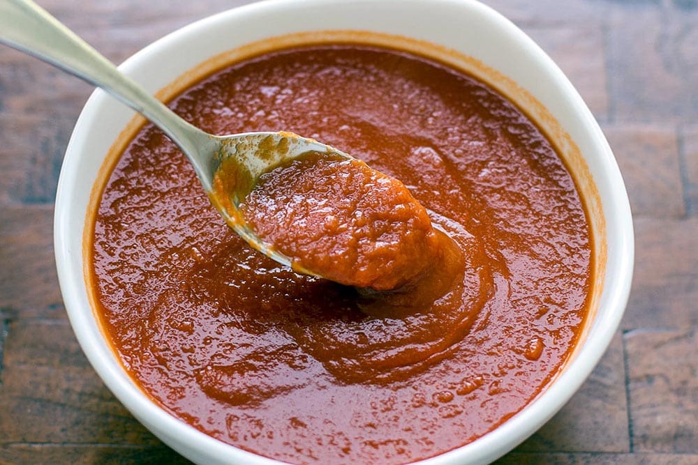 Oven tomato sauce (sauce tomate) in a white bowl with a spoon