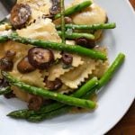 20-minute ravioli with asparagus and mushrooms on a white plate with a fork