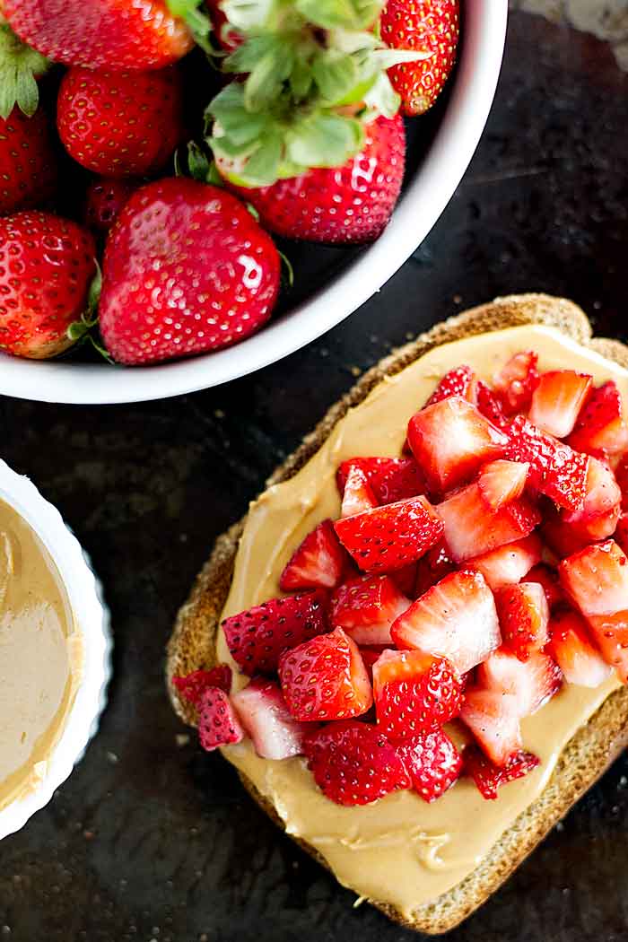 strawberry toast with a bowl of whole strawberries