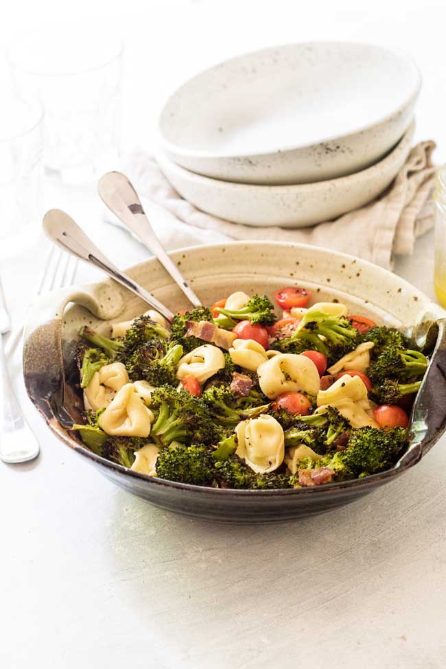 Tortellini Pasta Salad with Roasted broccoli in a bowl with two serving spoons