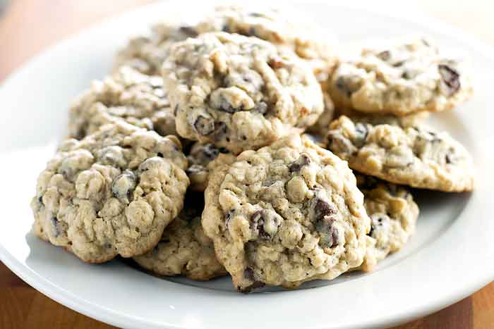 Oatmeal raisin cookies with chocolate chips on a white plate