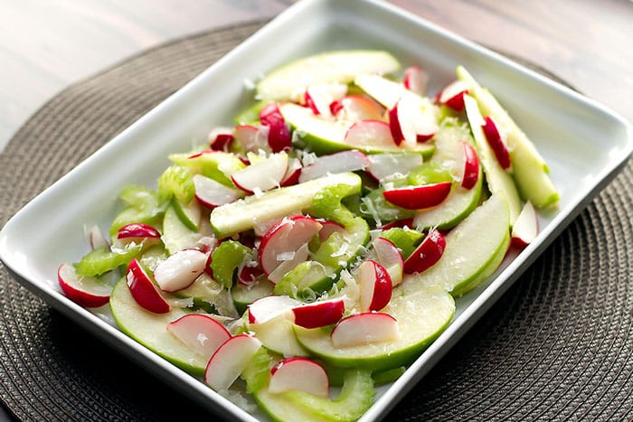radish and green apple salad in a white dish