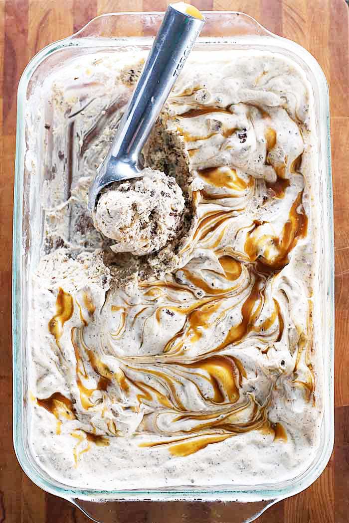 Caramel brownie no churn ice cream in a large dish with an ice cream scoop