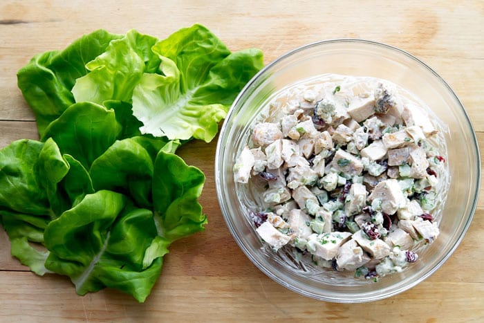 chicken salad in a bowl with lettuce leaves on the side
