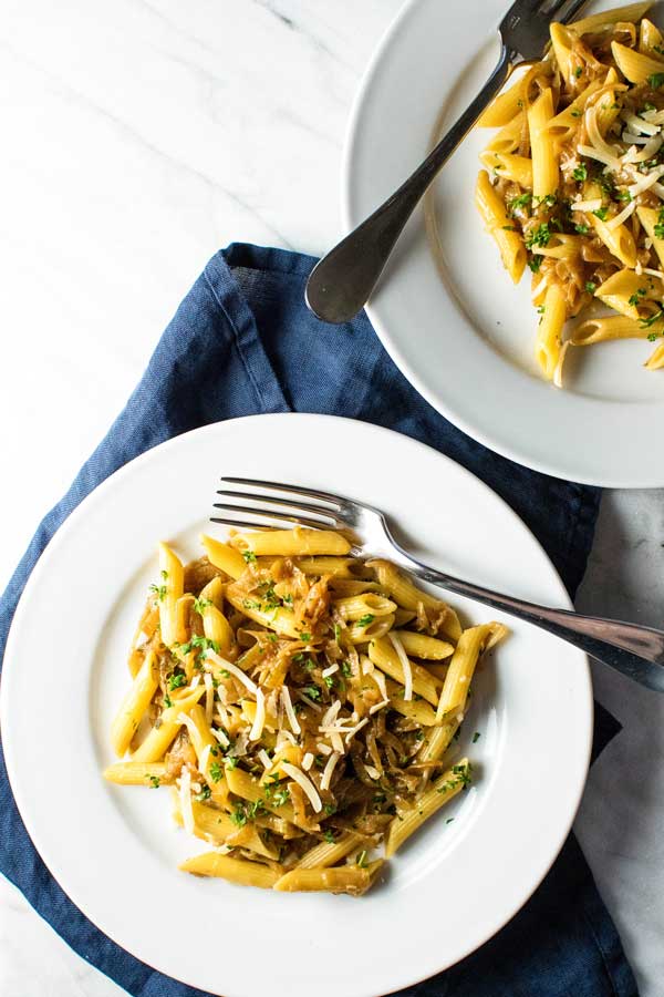 two servings of caramelized onion pasta on white plates