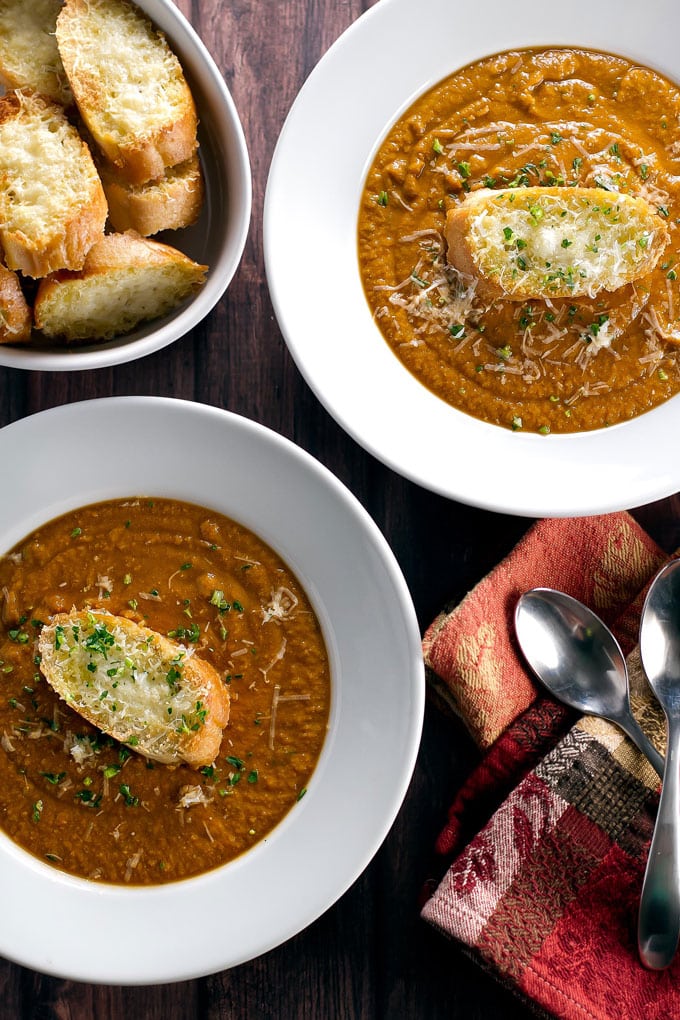 two bowls of soup garnished with crostini.