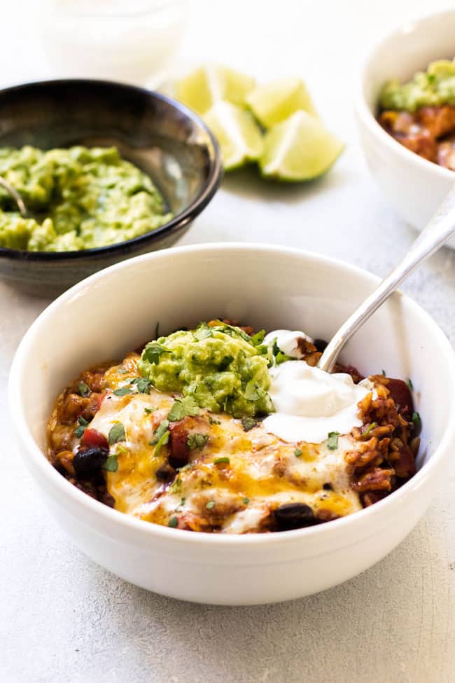 Loaded Mexican rice in a bowl with guacamole and sour cream
