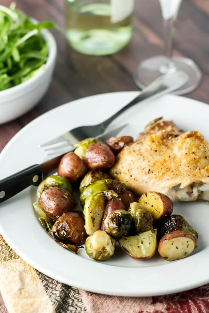 photo of a plate with roasted chicken thigh and veggies