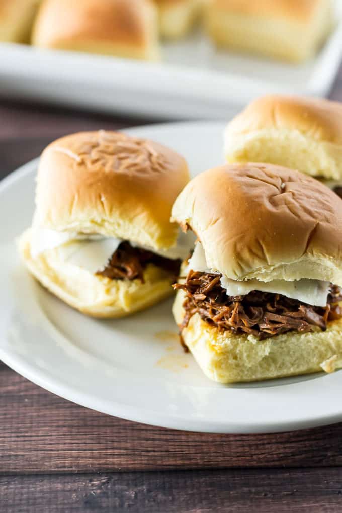 close-up photo of short rib sliders on a white plate