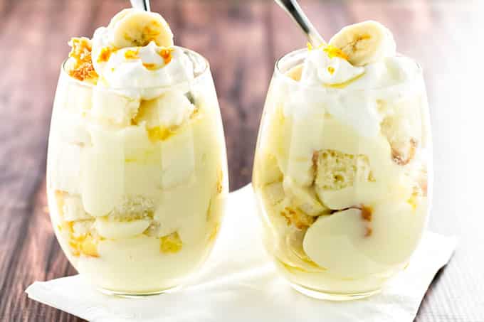 two banana pudding parfaits garnished with fresh whipped cream
