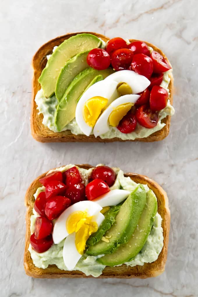 overhead photo of two loaded avocado toasts