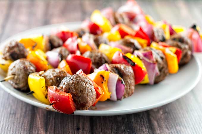 Ifour Italian beef skewers on a white plate