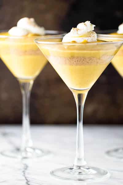 Pumpkin pudding parfaits in serving glasses and garnished with a dollop of whipped cream