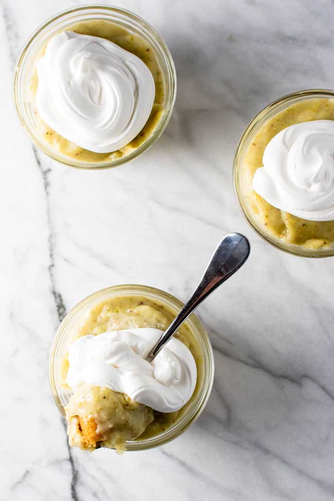 three pistachio pudding parfaits on a marble board
