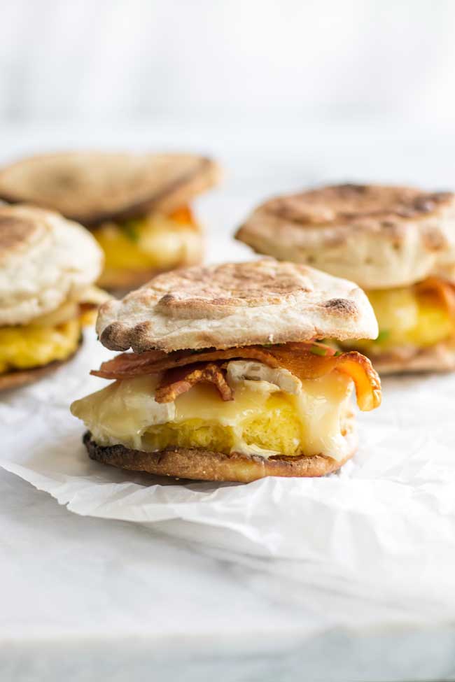 bacon brie breakfast sandwiches on parchment paper