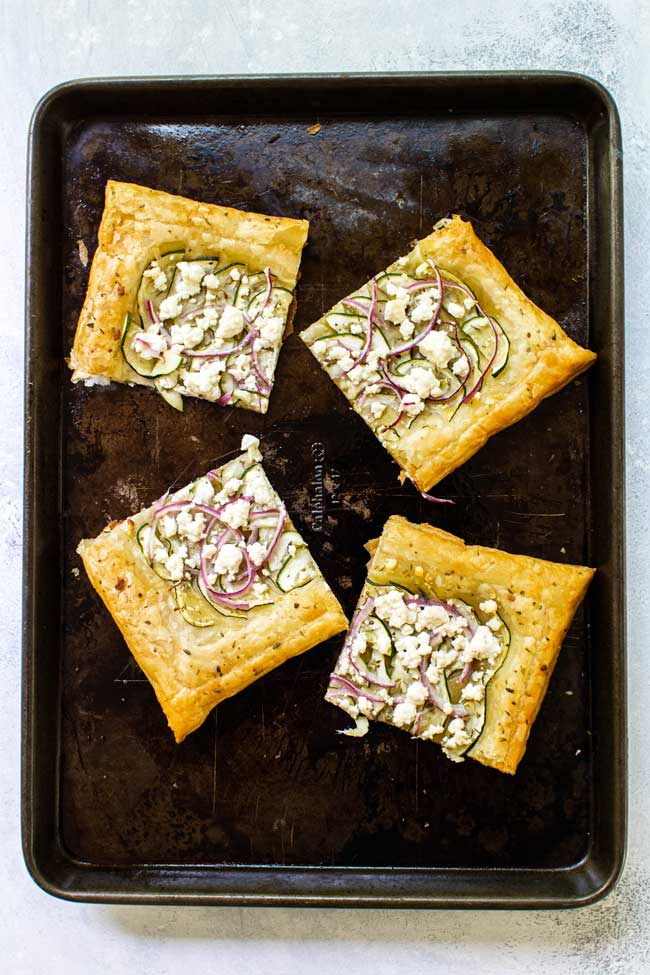 zucchini and goat cheese puff pastry tart cut into four pieces