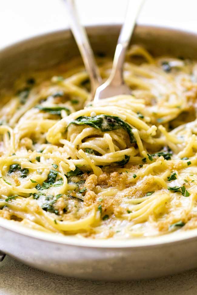 Creamy Gruyere Spaghetti with breadcrumbs and spinach in a skillet