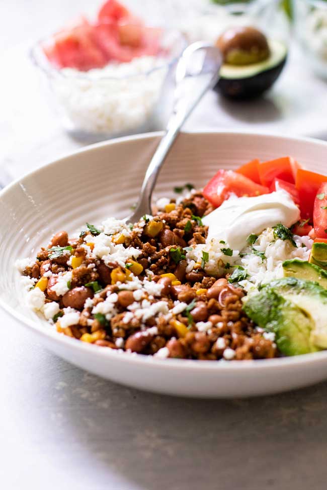 ground turkey taco bowl with cheese and an avocado 