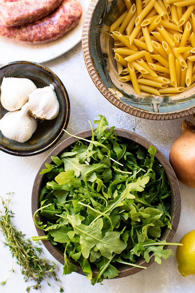 Ingredients for one-pot penne with sausage and arugula