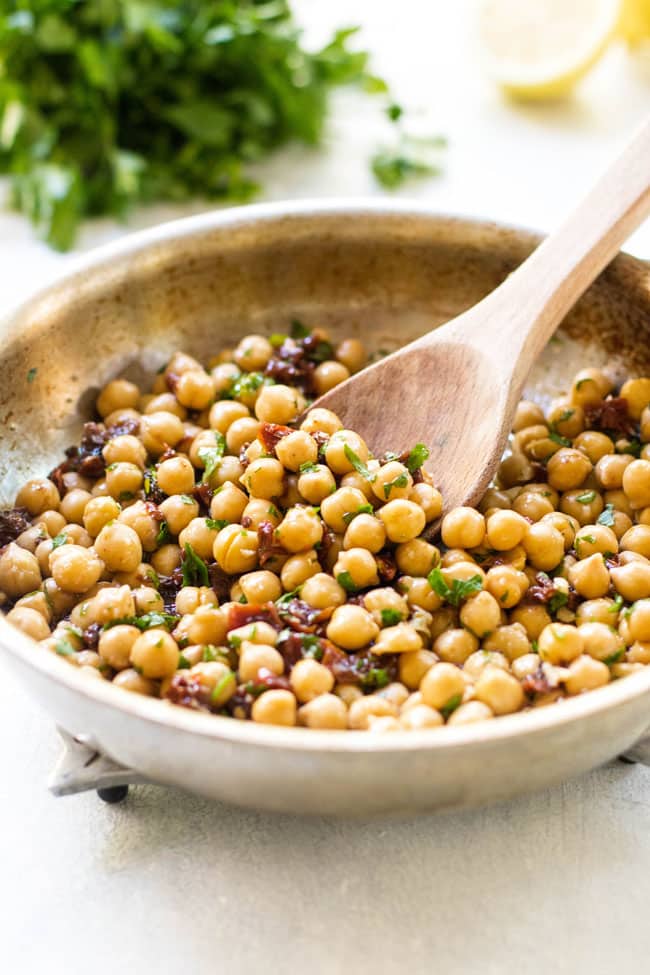 Chickpeas, sun-dried tomatoes, and lemon juice in a skillet