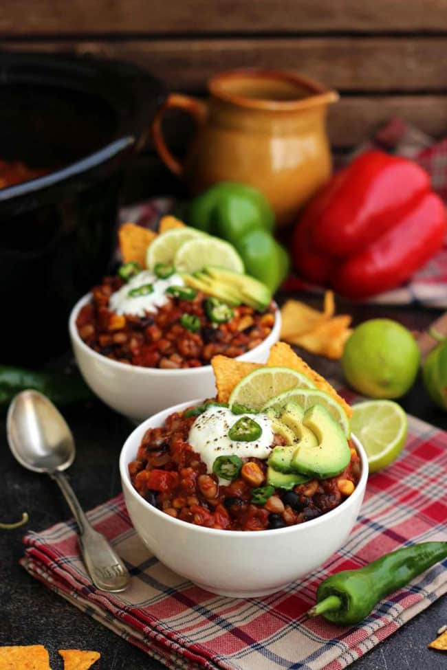 Two bowls of slow cooker vegan chili topped with sour cream