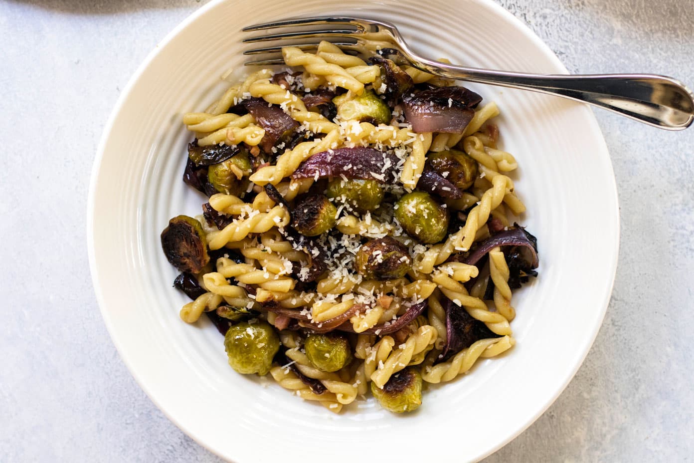 One serving of roasted vegetable pasta in a white bowl