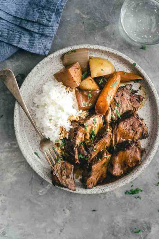 Asian-style slow cooker pot roast on a plate with rice and carrots