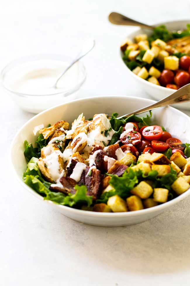 A bowl of Chicken BLT salad with some yogurt-mayo dressing drizzled over the top.