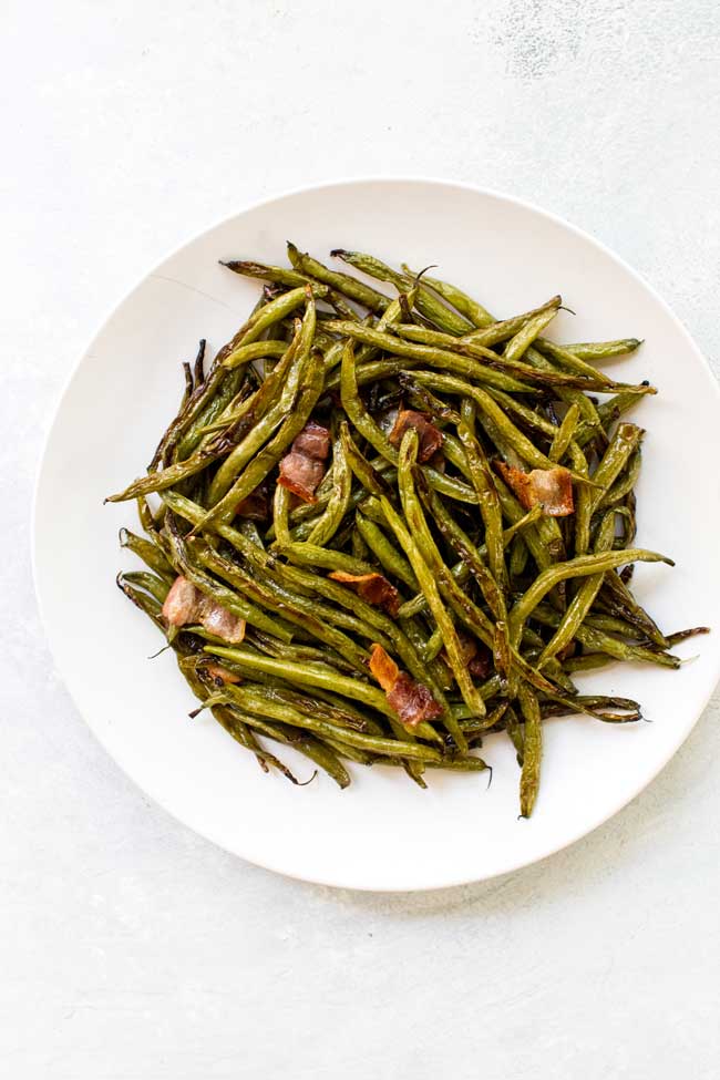 Roasted green beans on a white plate