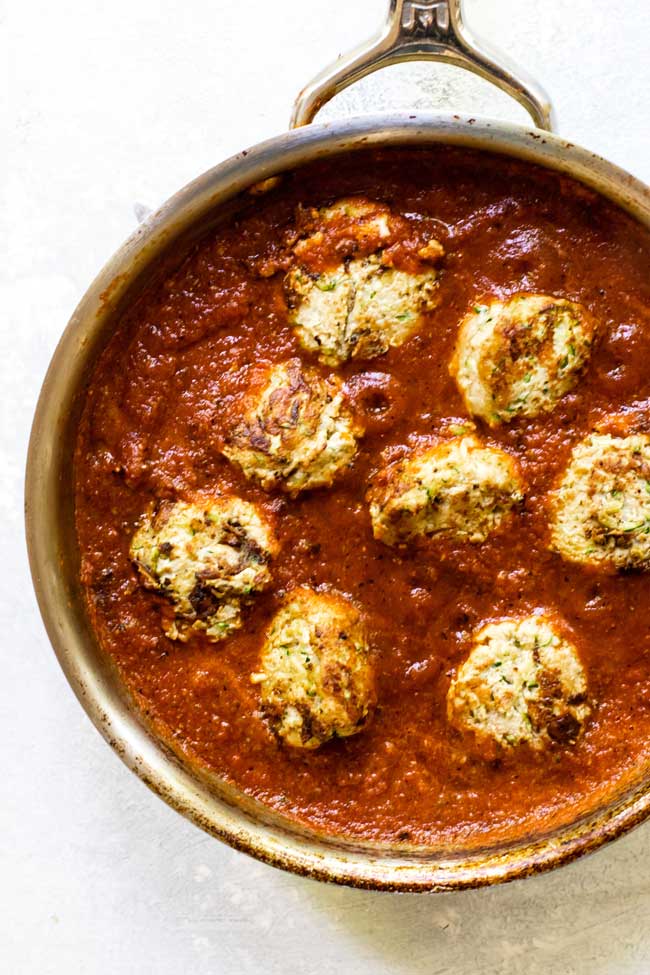 zucchini turkey meatballs in roasted red pepper sauce in a skillet