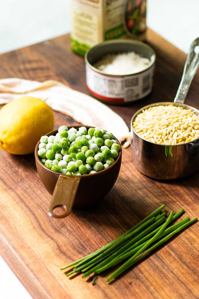 Ingredients for bacon orzo with crab on a cutting board