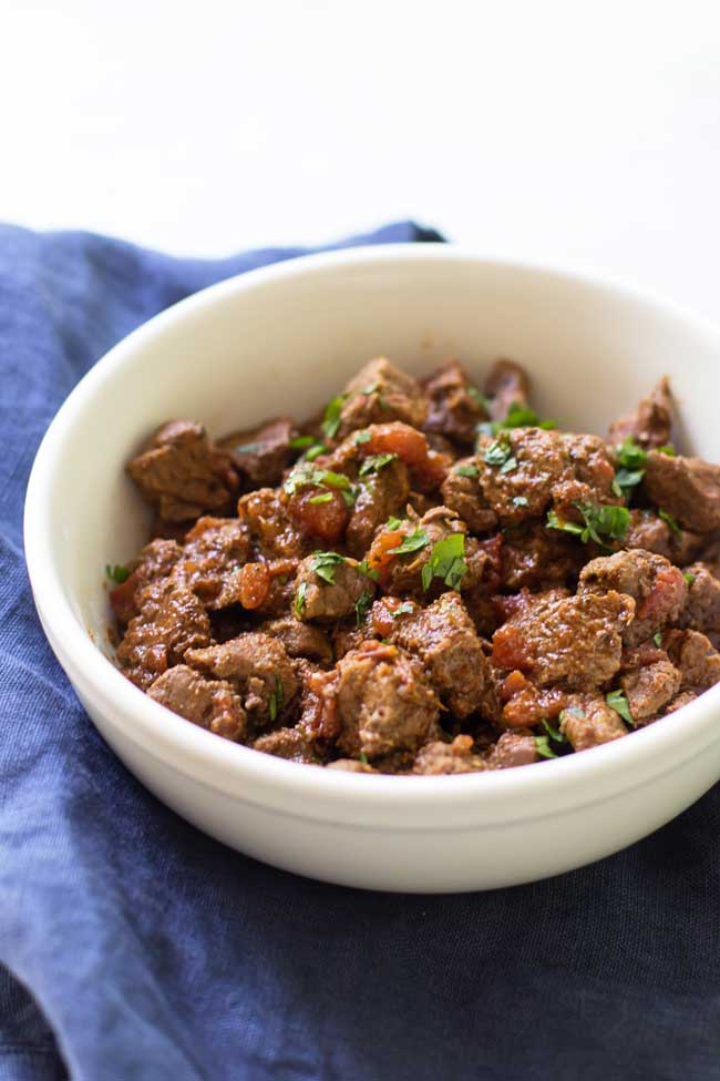 a white bowl filled with braised beef