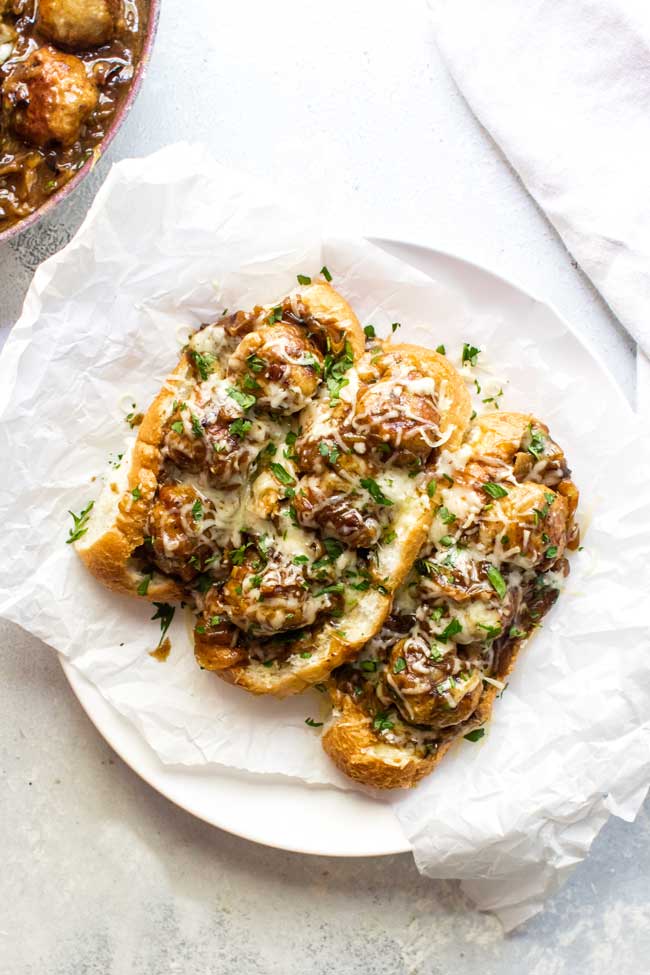 overhead photo of french onion chicken meatball sandwiches on a plate