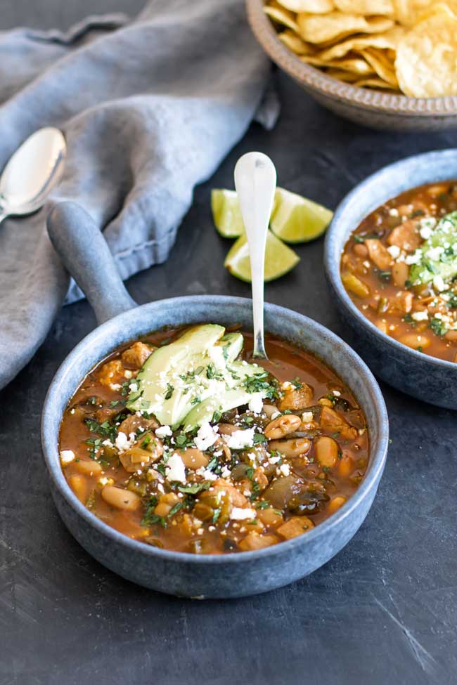 Photo of a bowl of chili garnished with avocado and cheese