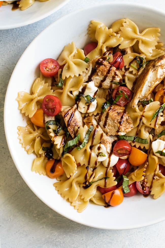 overhead photo of a bowl of balsamic glazed chicken with caprese pasta