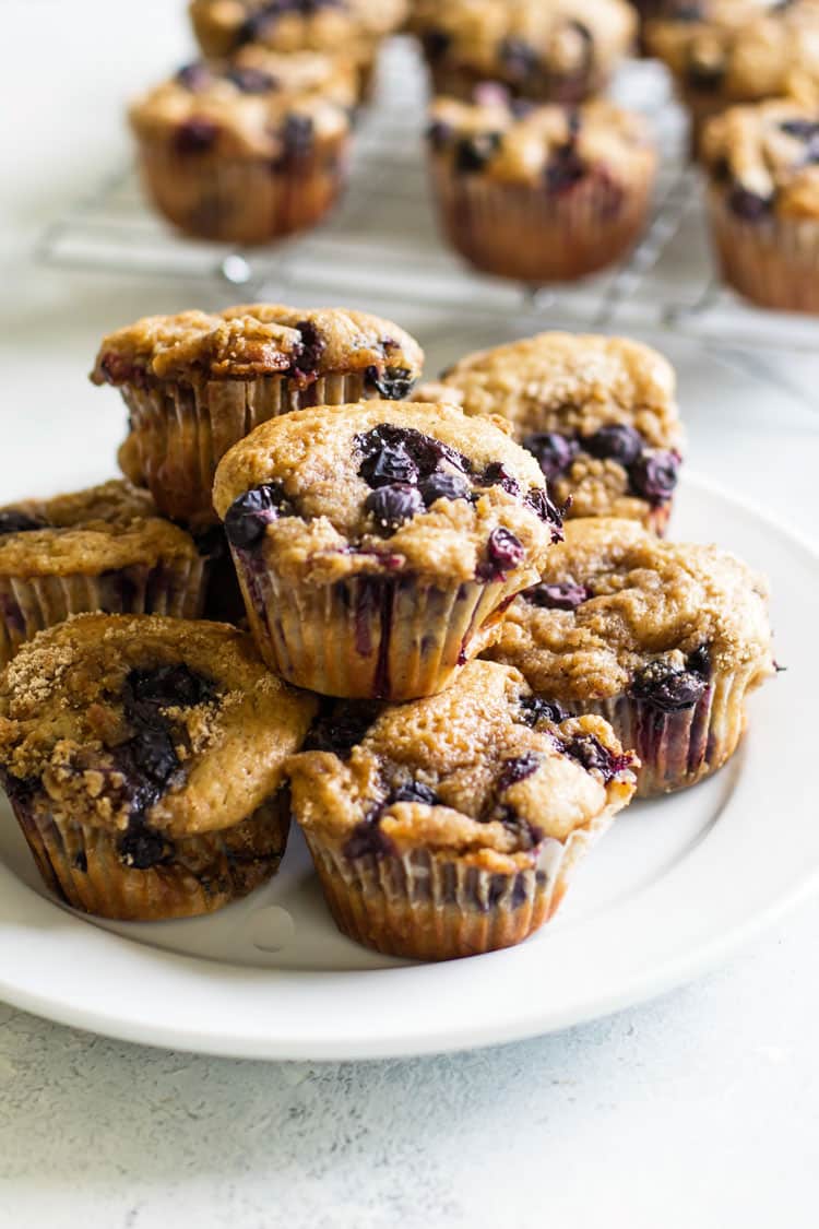 photo of blueberry buttermilk muffins stacked on a plate