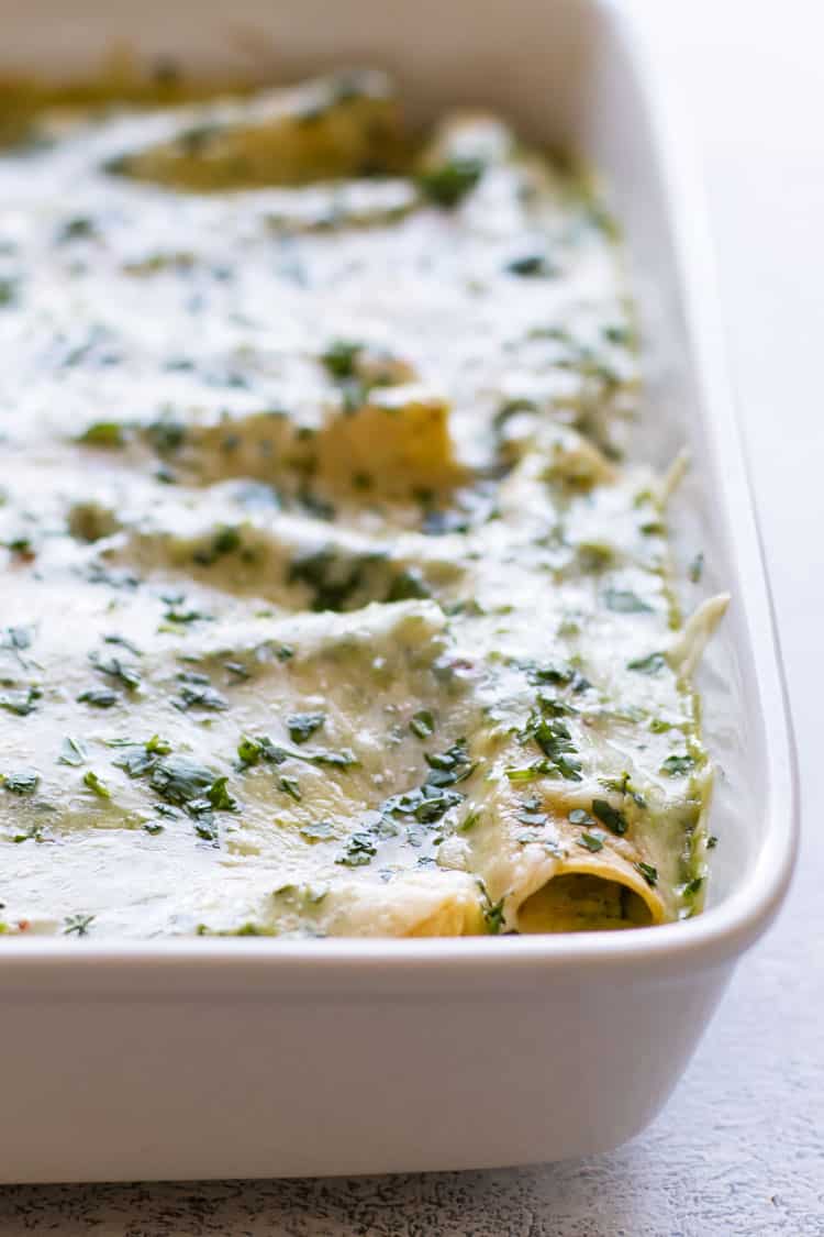 close up photo of a pan of chicken enchiladas